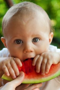 Photo d'un bébé en train de manger une pastèque