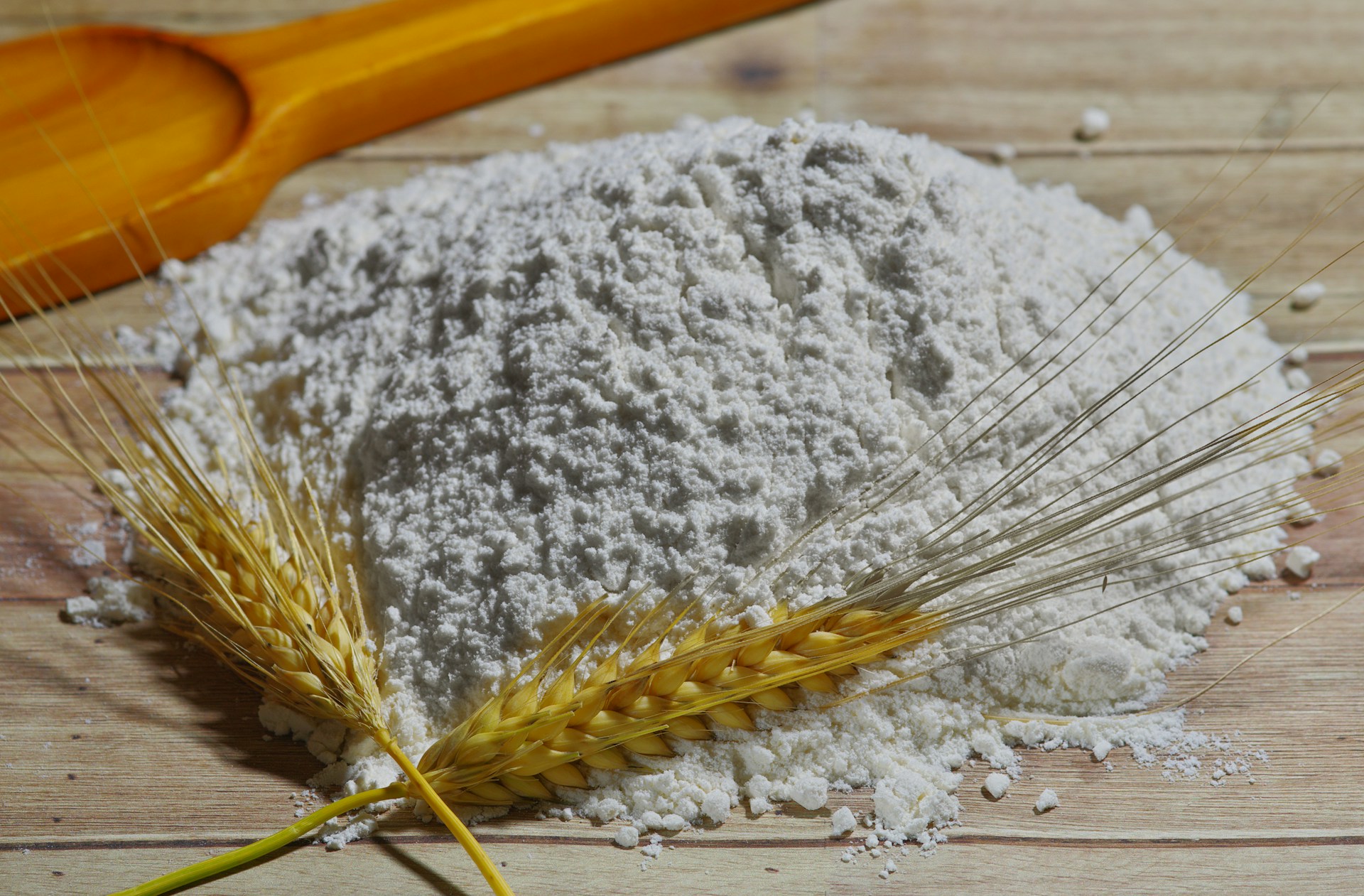 Farine de blé avec deux épis devant le tas de farine